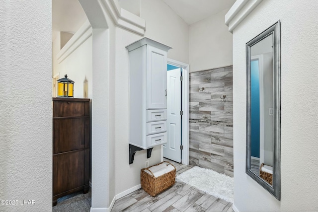 hallway with wood finish floors and arched walkways