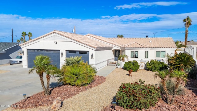 ranch-style house with fence, an attached garage, stucco siding, concrete driveway, and a tile roof