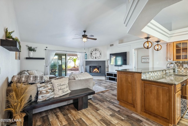 bedroom with visible vents, access to outside, a sink, a glass covered fireplace, and dark wood-style floors