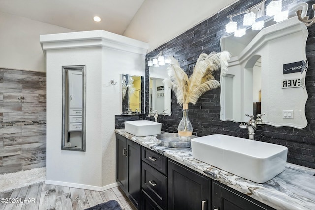 full bathroom with double vanity, wood tiled floor, and a sink