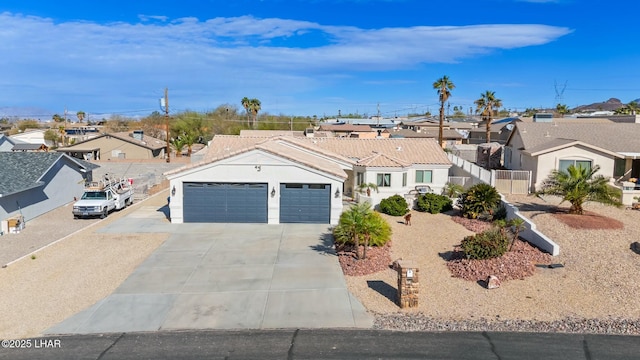 single story home with stucco siding, fence, a residential view, concrete driveway, and a garage