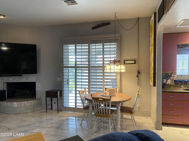 211 Columbine Dr, Lake Havasu City, AZ 86403 - dining area featuring visible vents, a fireplace with raised hearth, and marble finish floor