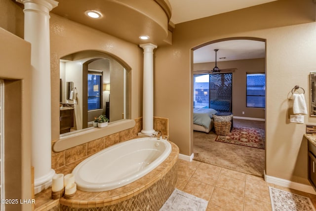 ensuite bathroom featuring a garden tub, decorative columns, vanity, ensuite bath, and tile patterned flooring