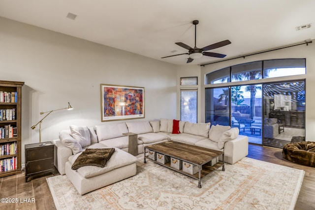 living area with ceiling fan, wood finished floors, and visible vents