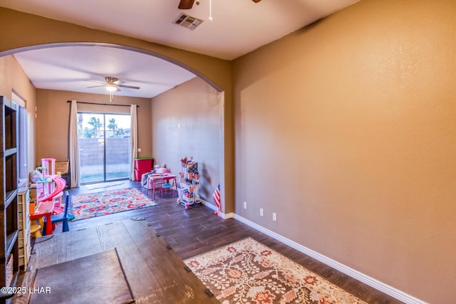 recreation room featuring ceiling fan, visible vents, and arched walkways