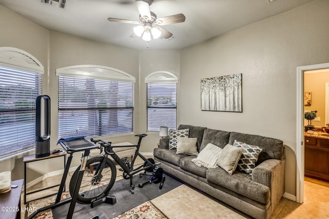 living room featuring a healthy amount of sunlight, baseboards, visible vents, and a ceiling fan