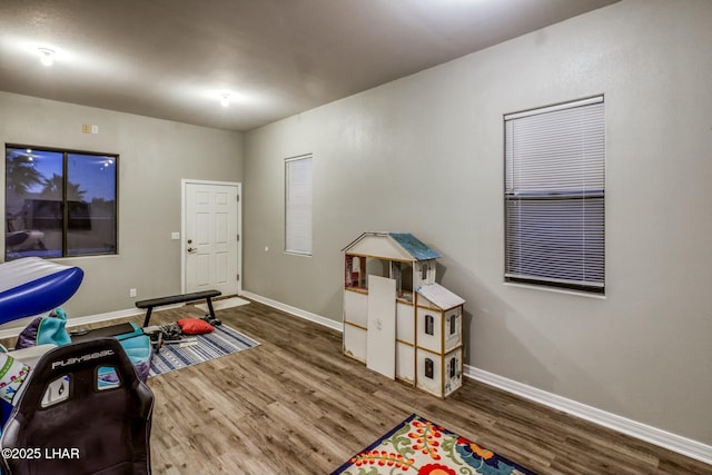 rec room with baseboards and wood finished floors