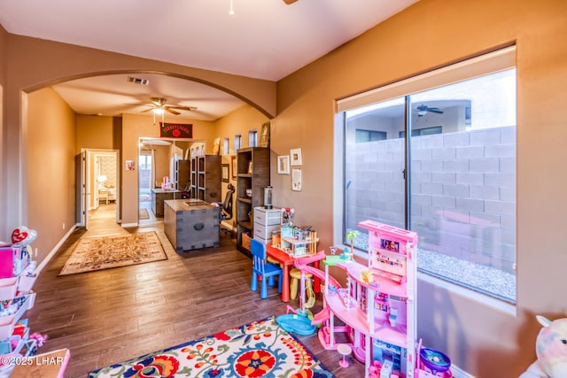 game room featuring arched walkways, visible vents, wood finished floors, and a ceiling fan