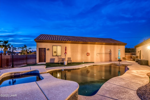 view of swimming pool featuring a pool with connected hot tub, fence, and a patio