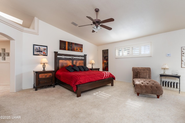 carpeted bedroom with arched walkways, lofted ceiling, visible vents, baseboards, and a ceiling fan