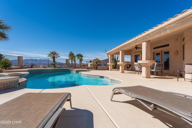 view of pool featuring a ceiling fan, a pool with connected hot tub, a patio area, and fence