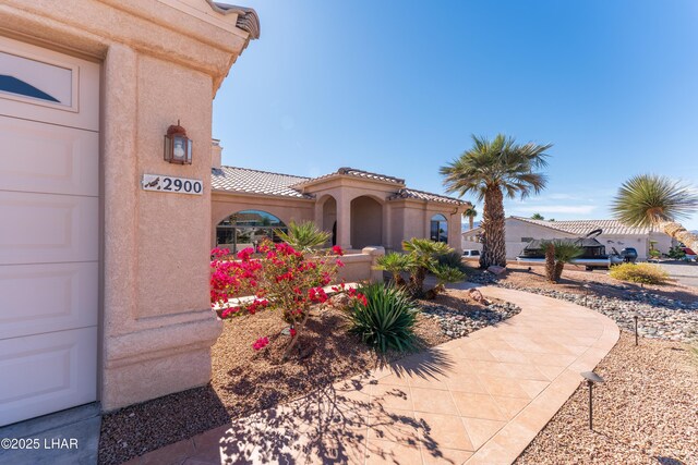 exterior space with a tile roof and stucco siding