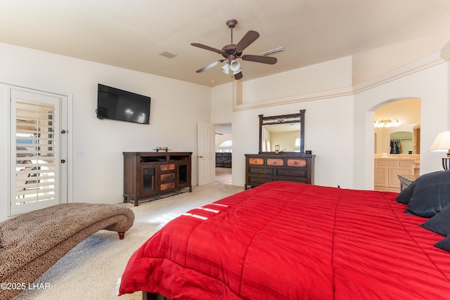 bedroom featuring arched walkways, carpet flooring, visible vents, and ensuite bathroom