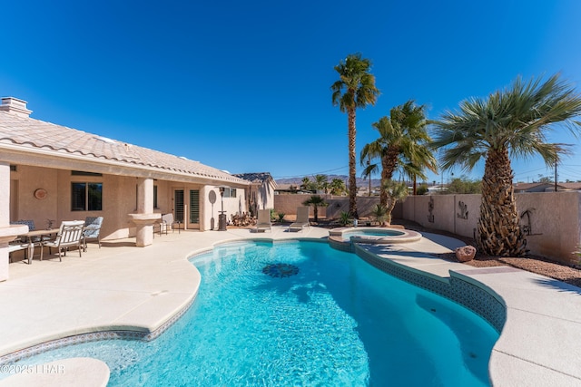 view of pool with a patio area, a fenced backyard, and a pool with connected hot tub