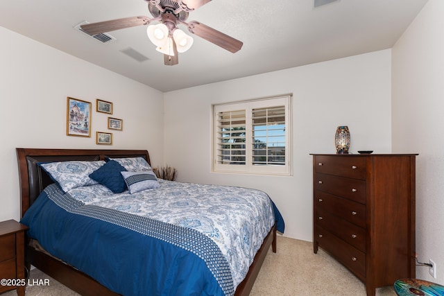 bedroom featuring visible vents, a ceiling fan, and light colored carpet