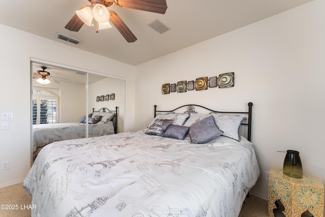 carpeted bedroom featuring a ceiling fan, visible vents, and a closet