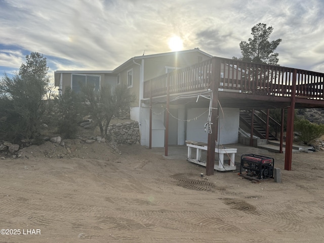 back of house featuring stairs and a wooden deck