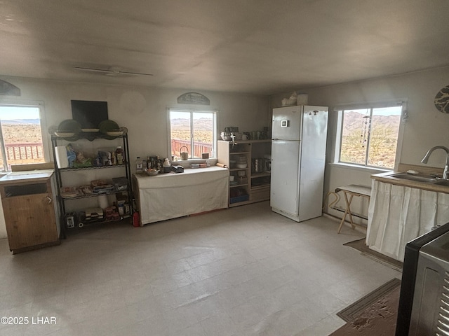 miscellaneous room with light floors and a sink