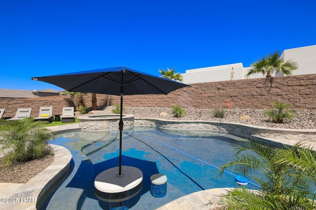 view of pool with a pool with connected hot tub and fence