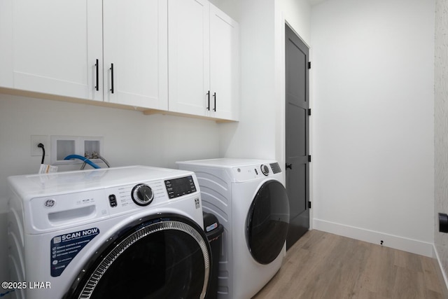 washroom featuring cabinet space, independent washer and dryer, light wood-type flooring, and baseboards