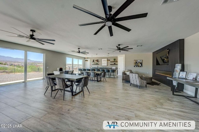 dining space featuring light wood-type flooring, ceiling fan, and visible vents