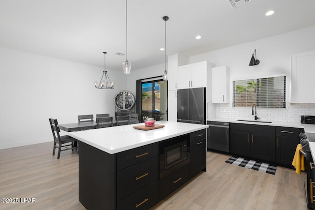 kitchen featuring dark cabinets, a sink, white cabinetry, and black appliances