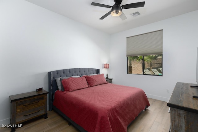 bedroom with visible vents, baseboards, a ceiling fan, and wood finished floors