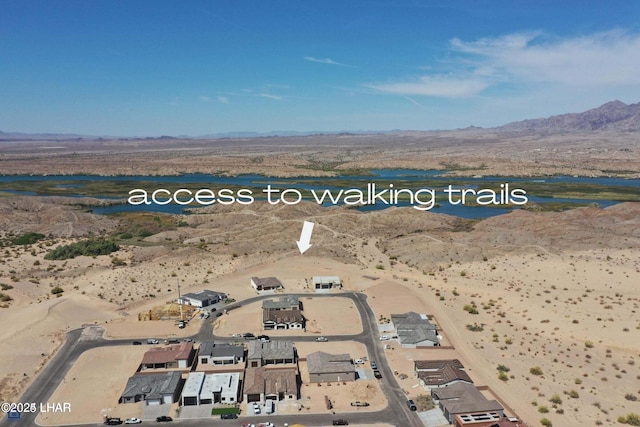aerial view with a water and mountain view and view of desert