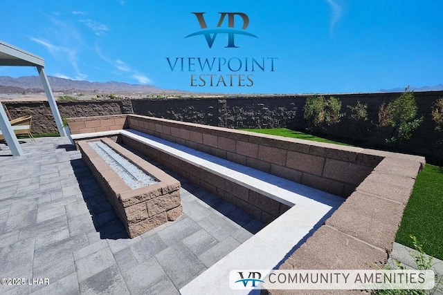 view of swimming pool featuring fence, a patio area, a mountain view, and an outdoor fire pit