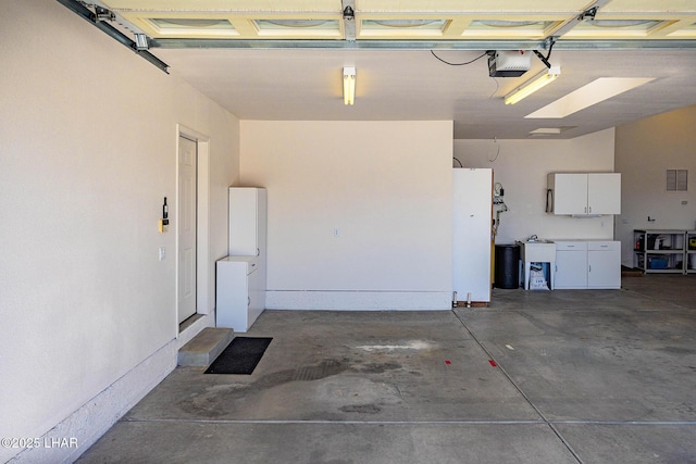 garage featuring a garage door opener and visible vents