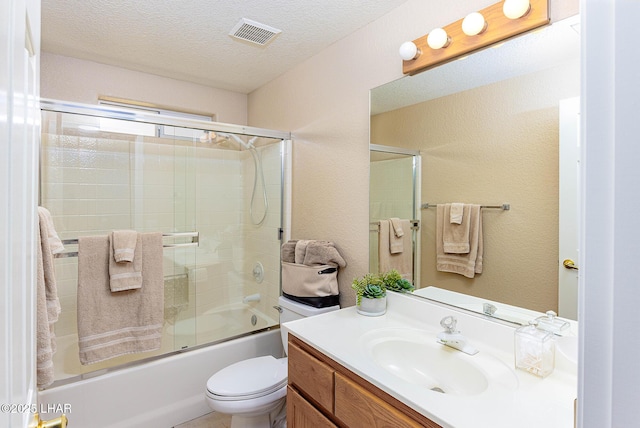 full bathroom with visible vents, toilet, combined bath / shower with glass door, a textured ceiling, and vanity