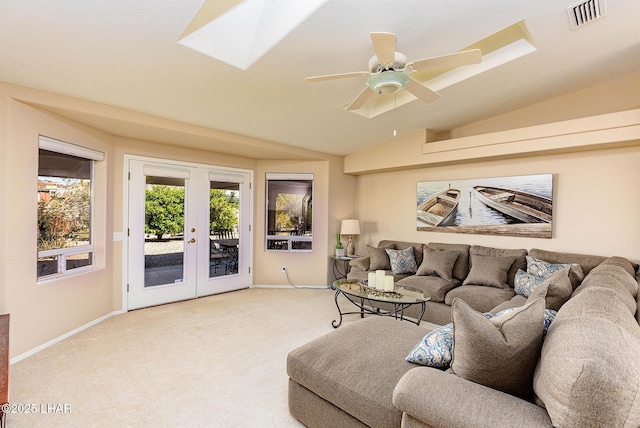 living area featuring vaulted ceiling with skylight, visible vents, baseboards, french doors, and carpet