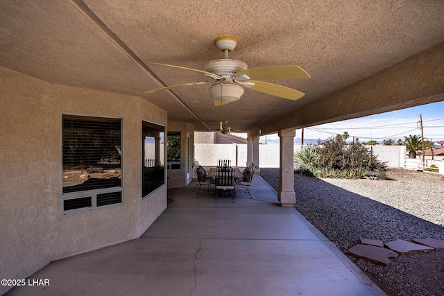 view of patio with ceiling fan and fence