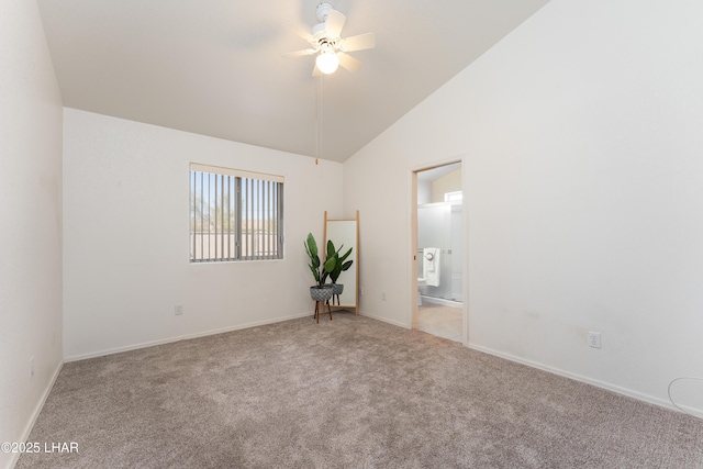 carpeted spare room featuring baseboards, a ceiling fan, and vaulted ceiling