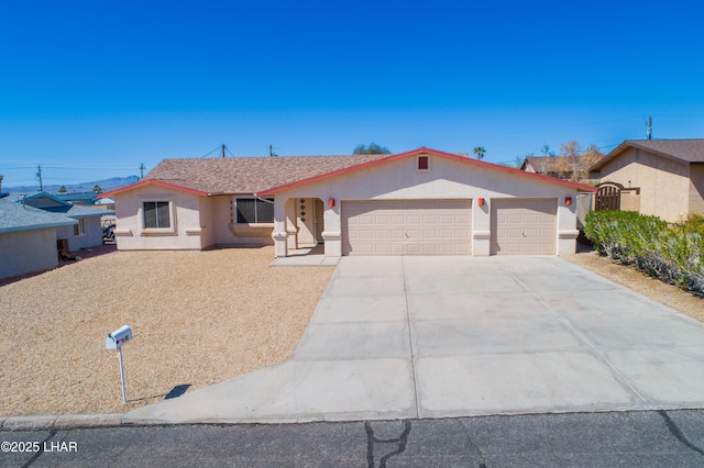 ranch-style home with stucco siding, a garage, and driveway