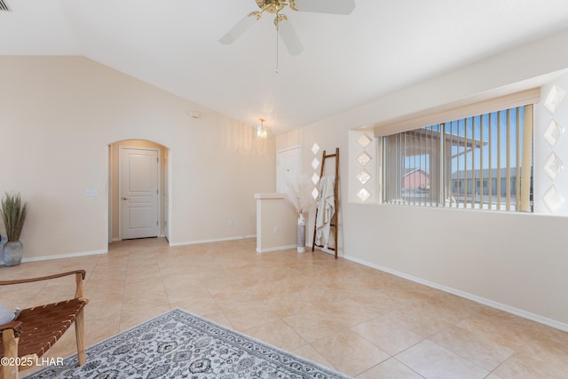 interior space featuring vaulted ceiling, arched walkways, baseboards, and tile patterned floors