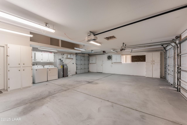 garage with washer and clothes dryer, water heater, and a garage door opener