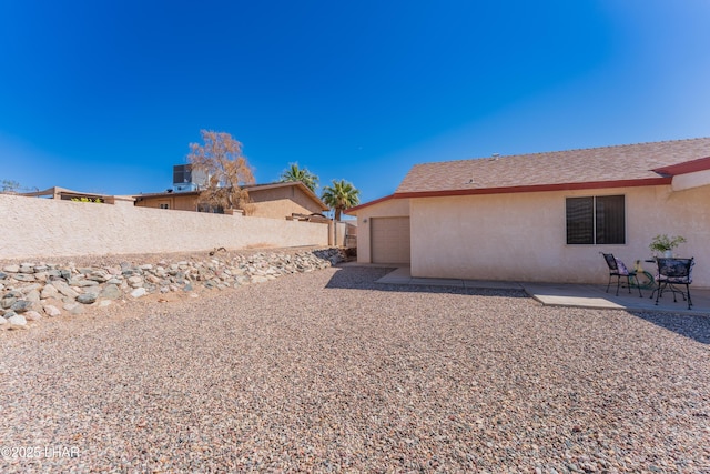 view of yard with a patio, fence, and a garage