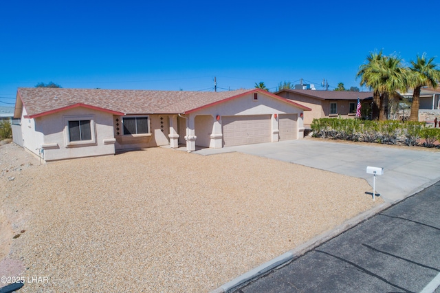 ranch-style house featuring a garage, driveway, and stucco siding