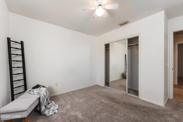 unfurnished bedroom with visible vents, a ceiling fan, a closet, carpet, and baseboards