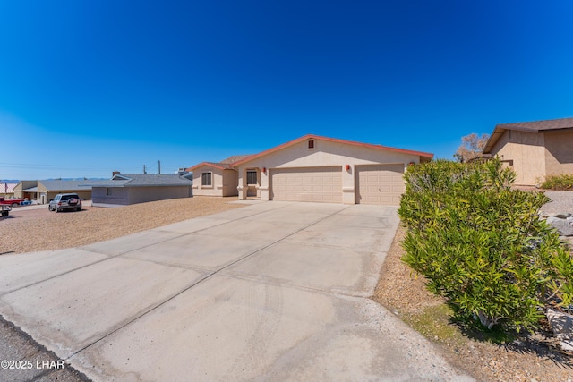 view of front of home featuring stucco siding, a garage, and driveway