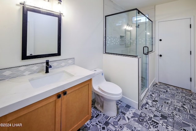 bathroom with vanity, tasteful backsplash, toilet, and walk in shower