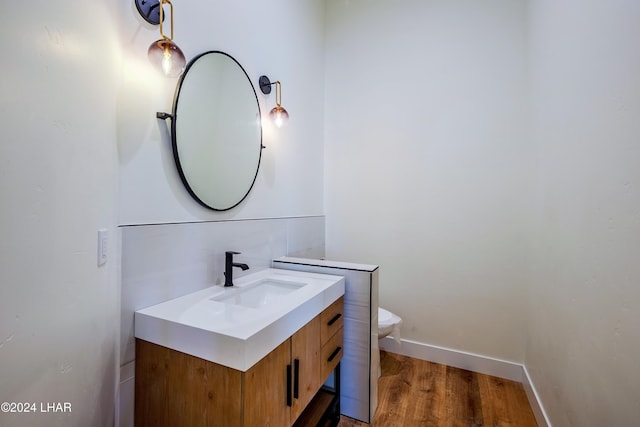 bathroom with vanity, wood-type flooring, and toilet