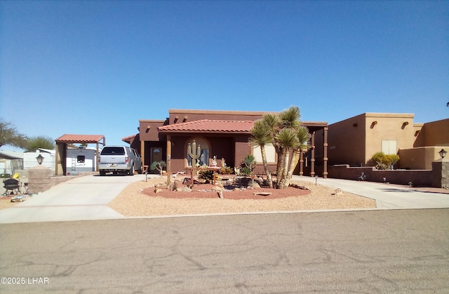 view of front of property with a tile roof, stucco siding, and concrete driveway