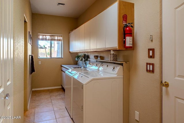 1972 E Bayshore Rd, Lake Havasu City, AZ 86404 - clothes washing area featuring visible vents, independent washer and dryer, cabinet space, light tile patterned floors, and baseboards