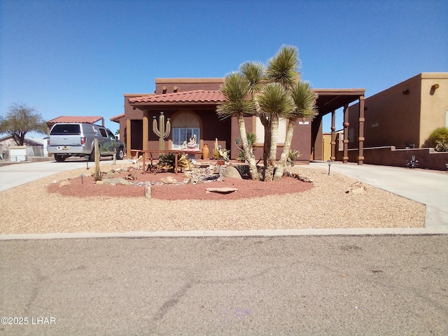 view of front facade with stucco siding, driveway, and a tile roof