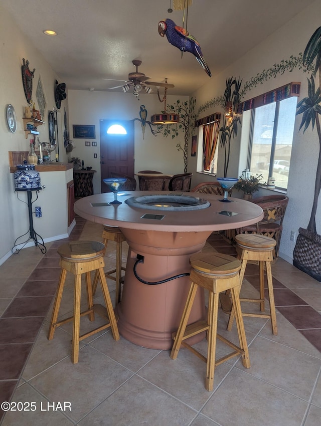 dining room with light tile patterned flooring, baseboards, and a ceiling fan