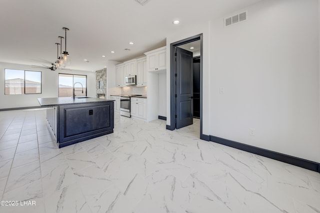 kitchen with tasteful backsplash, visible vents, appliances with stainless steel finishes, white cabinets, and a sink