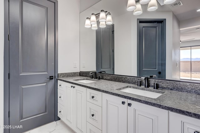 full bath featuring marble finish floor, double vanity, a sink, and visible vents