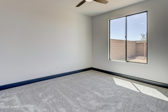 spare room featuring a ceiling fan, carpet flooring, and baseboards